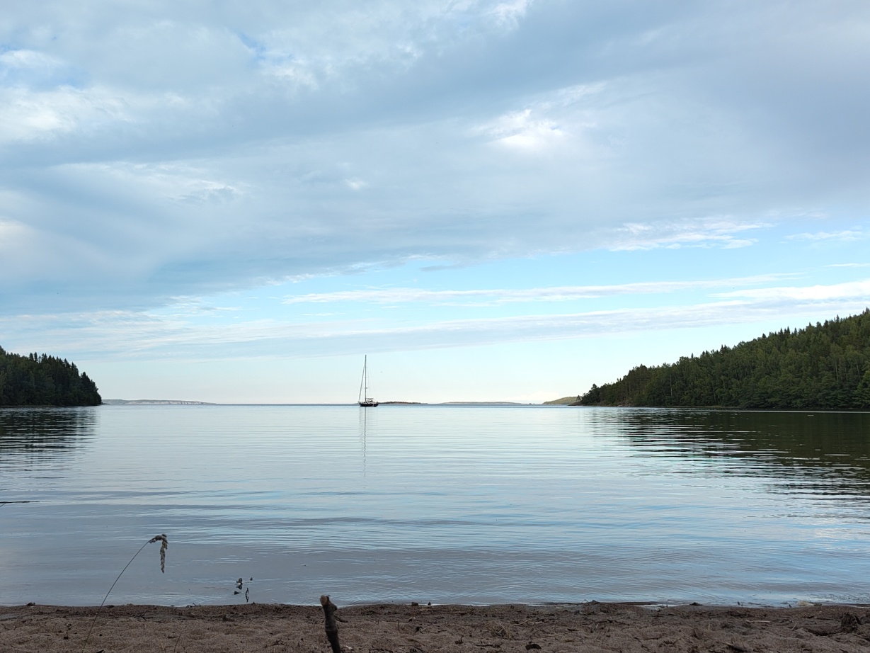 A view of Kälsviken with the baltic sea, there's a sailing boat anchoring in the distance