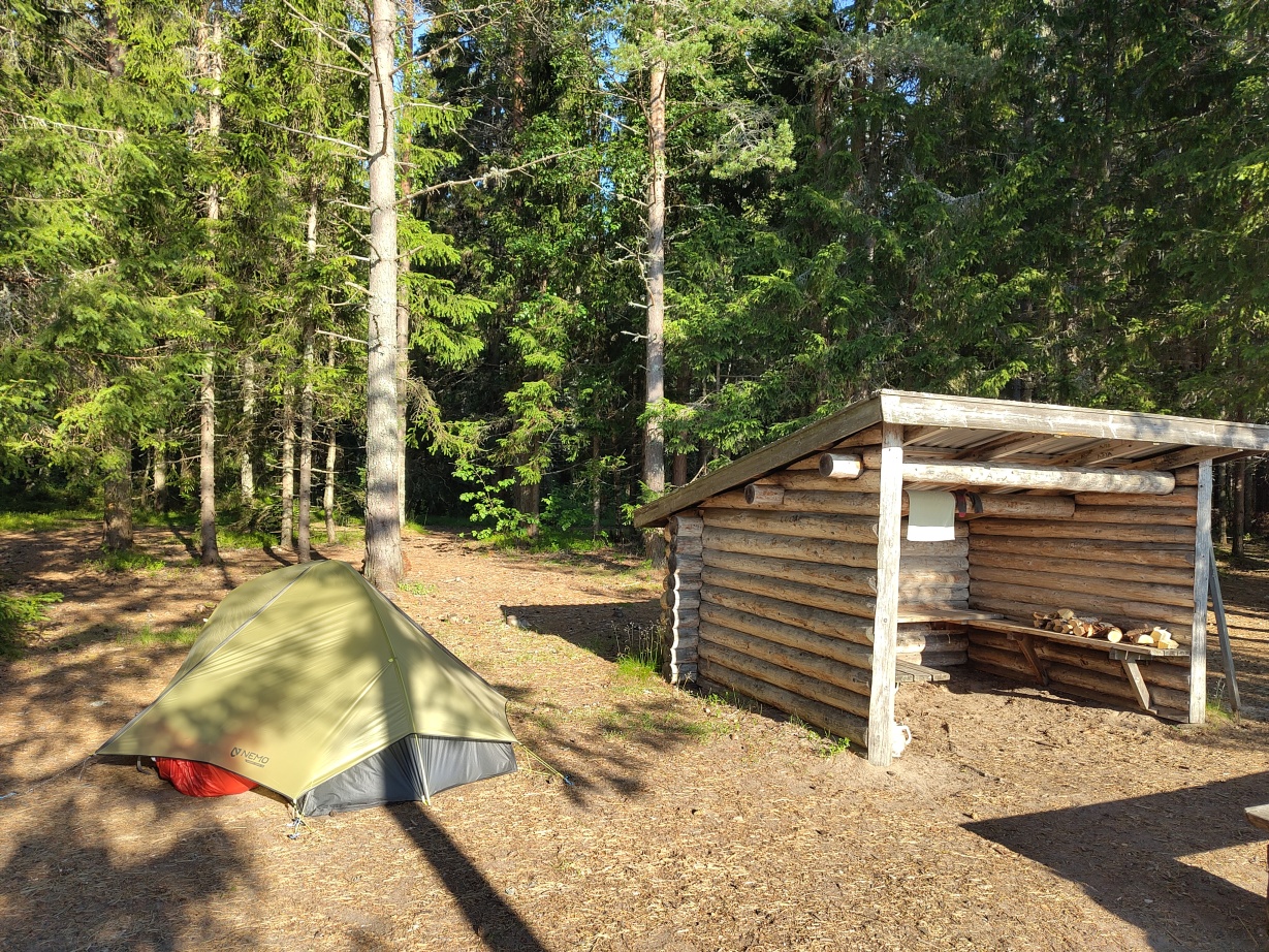 A view of our tent and the shelter with firewood at Kälsviken